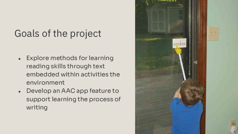 Child is pointing at the word "window" taped to a window. Slide also includes the goals of the project.